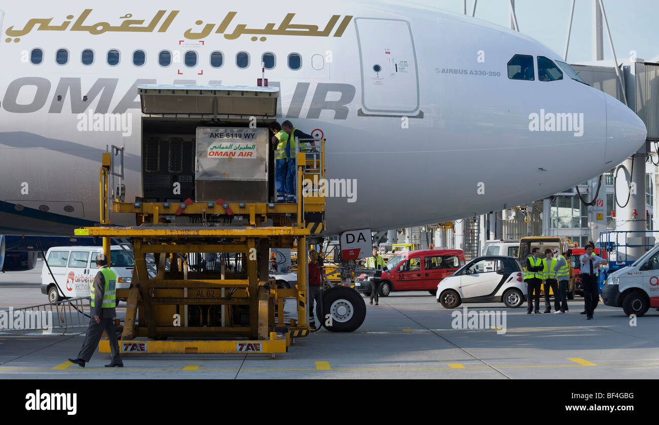 Ground Crew descarga un Airbus A330-200 de la aerolínea Air Omán, el aeropuerto de Munich, Baviera, Alemania, Europa Foto de stock
