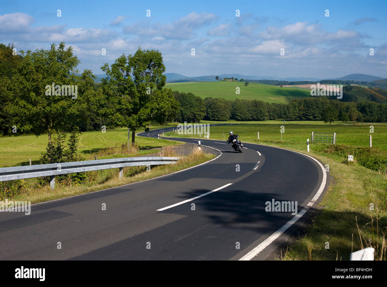 El motorista en un sinuoso camino campestre, Alemania, Europa Foto de stock