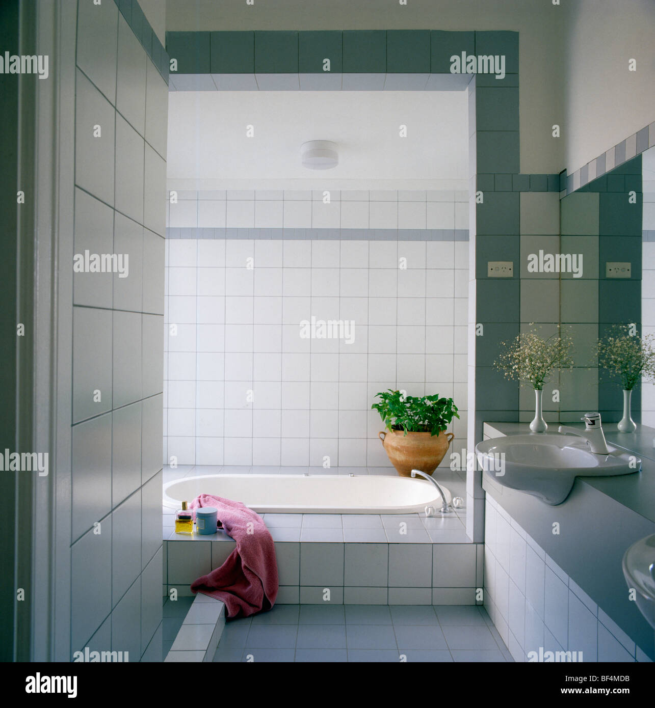 Cuarto de baño moderno, blanco y rosa con toalla de baño con ... Cuarto de baño moderno, blanco y rosa con toalla de baño con ...