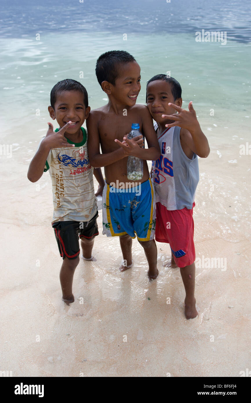 Tres jóvenes muchachos marshalés posan para la cámara en Laura Beach, Majuro, Islas Marshall. Foto de stock