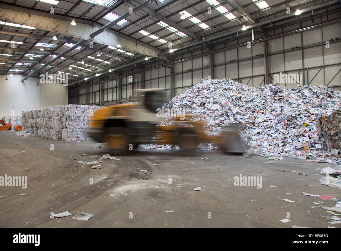 Bulldozer moviéndose en la fábrica de papel reciclado Foto de stock