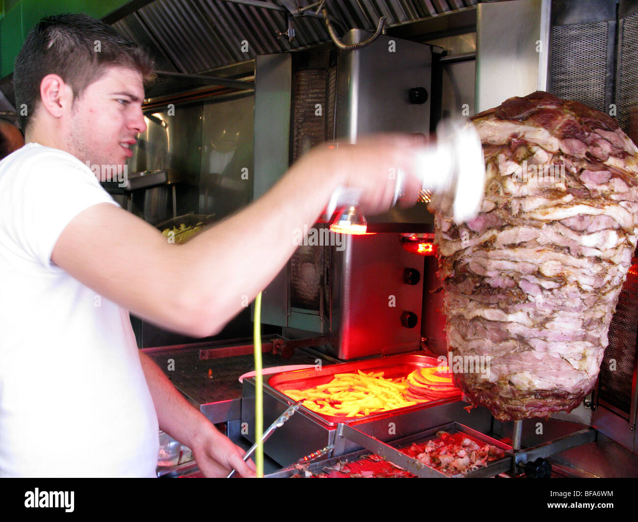 Hombre trocear la carne para hacer Souvlaki con Gyro Pita. Rethymnon,  Creta, Grecia Fotografía de stock - Alamy