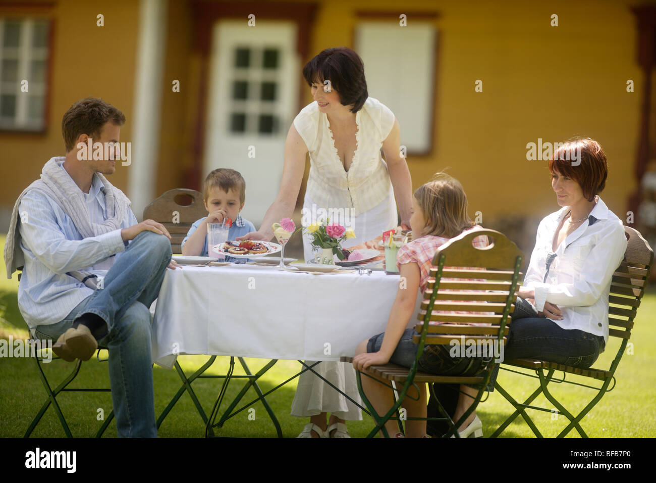 Familia sentado en la cafetería al aire libre Foto de stock