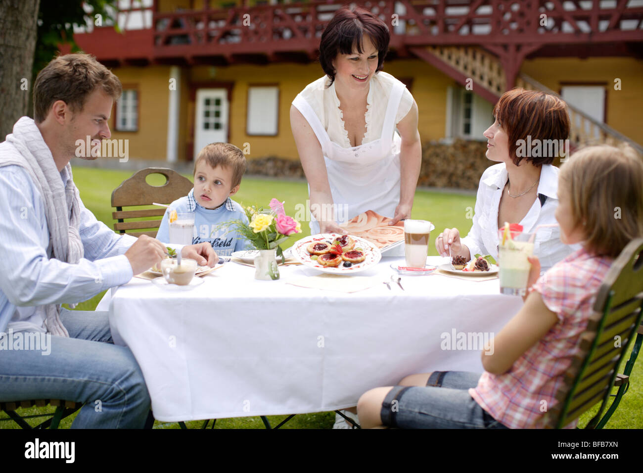 Familia sentado en la cafetería al aire libre Foto de stock