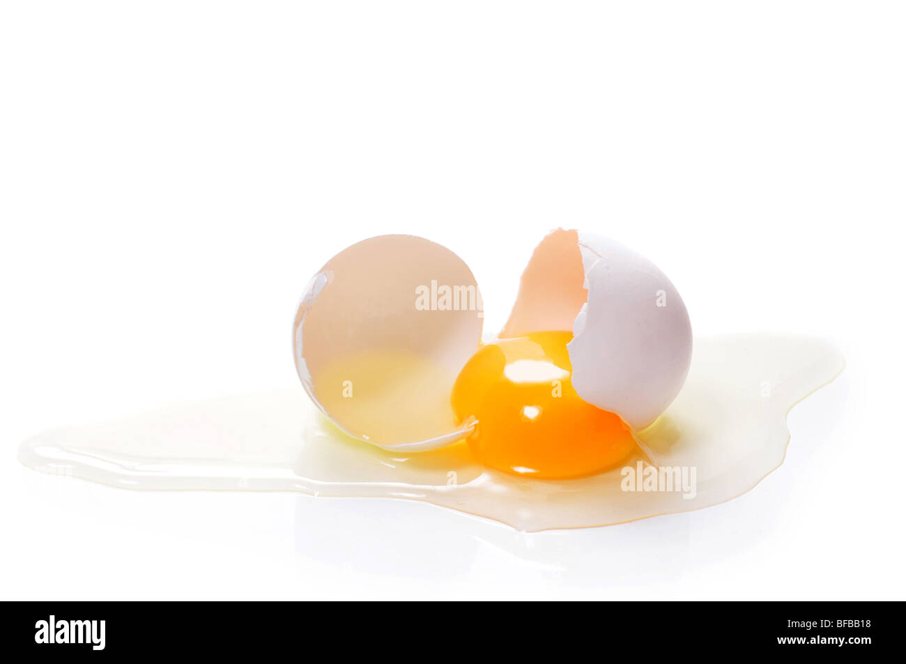 Huevos rotos sobre fondo blanco. Foto de stock