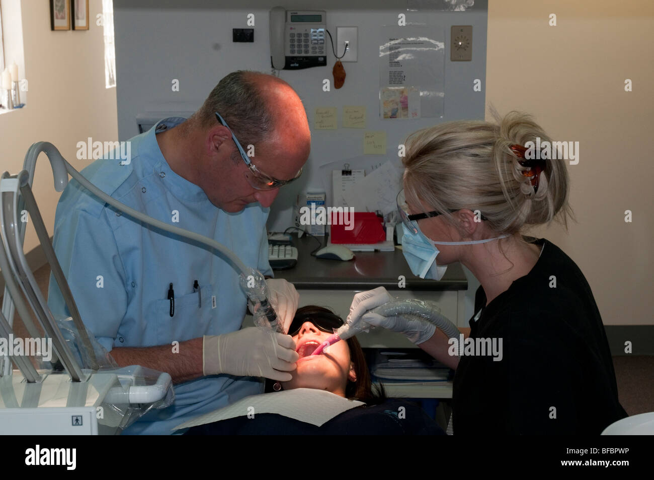 Dentista y asistente dental darle a un paciente en una cirugía dental moderna un chequeo regular Foto de stock