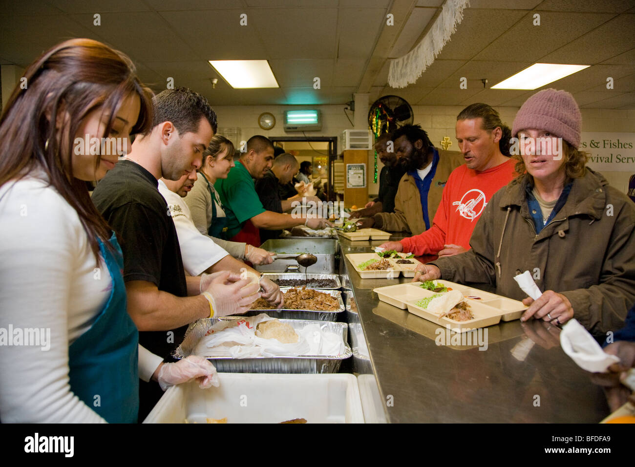La gente disfruta de una comida gratuita en los panes y los peces, sin ánimo de lucro que ayuda a las personas sin hogar en Sacramento, California. Foto de stock