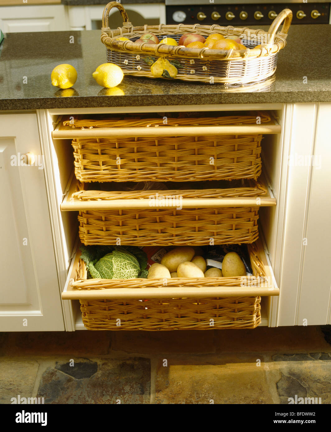 Close-up de almacenaje de cocina cestas en nata montada unidad con cesta de  frutas en la encimera de la cocina tradicional Fotografía de stock - Alamy