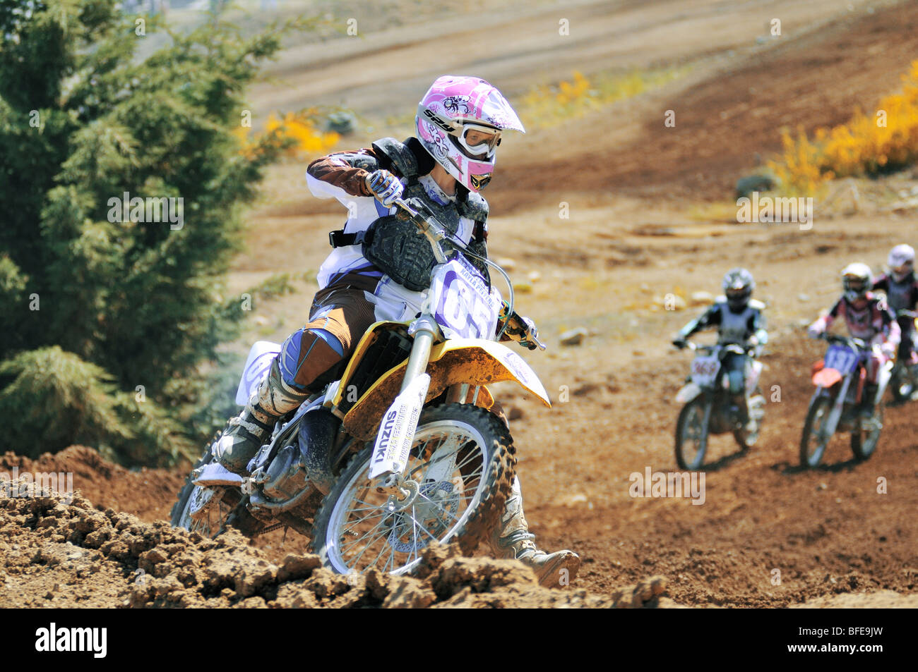 Motocross femenino racer redondeo esquina con otros corredores en persecución de Nanaimo eriales Nanaimo, British Columbia Vancouver Island Foto de stock