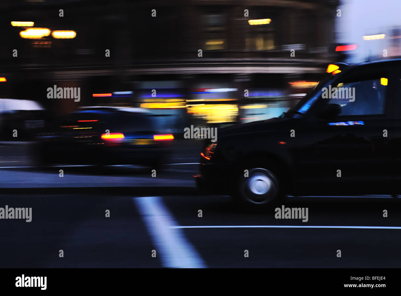 Un taxi de Londres negro capturado en movimiento al anochecer. Trafalgar Square, Londres, Reino Unido. Foto de stock