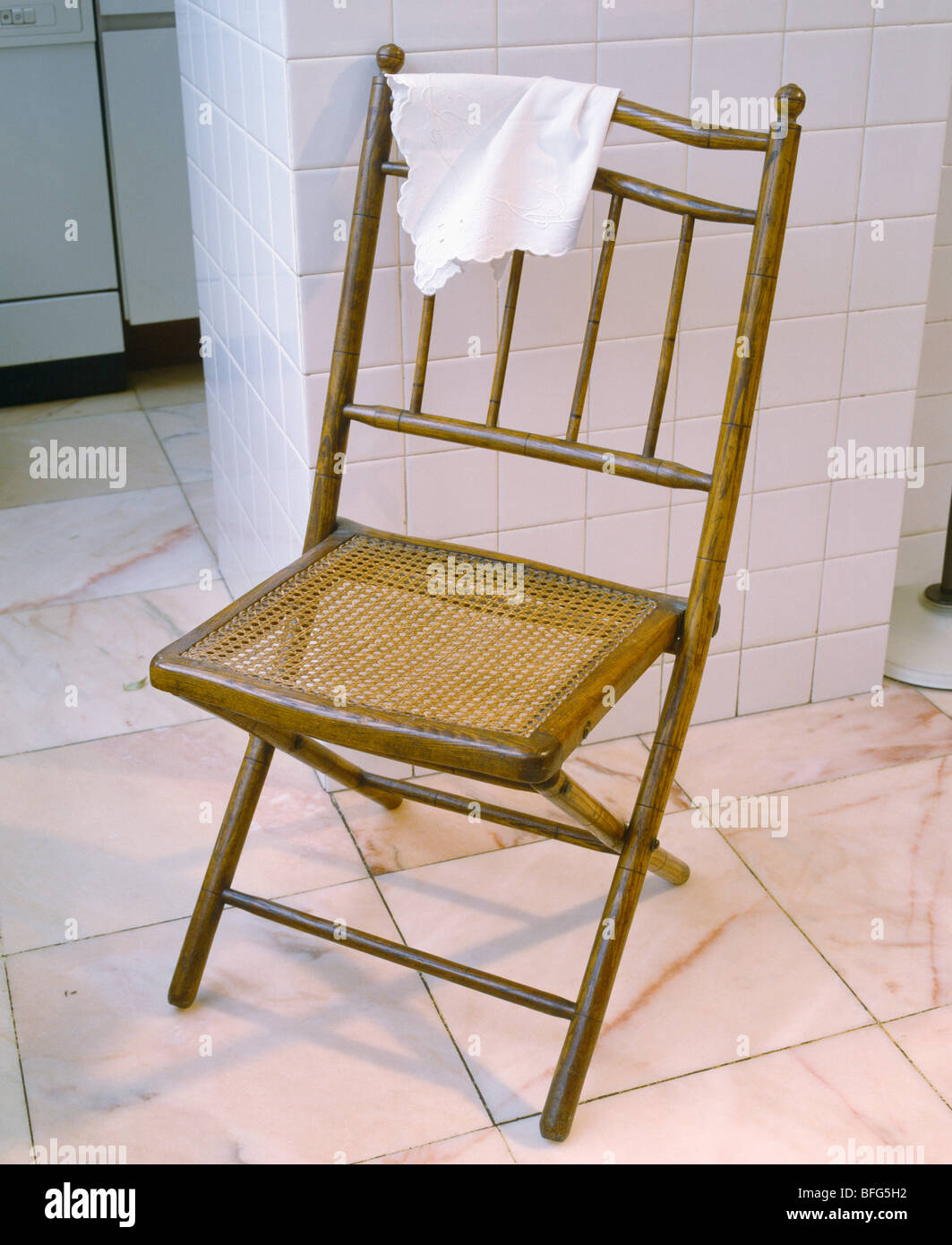 Antique de caña de bambú y silla plegable en el piso de baldosas blancas  Fotografía de stock - Alamy
