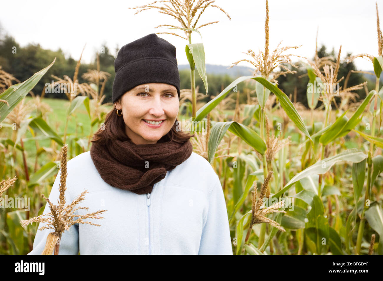 Mujer de pie en el campo de maíz Foto de stock