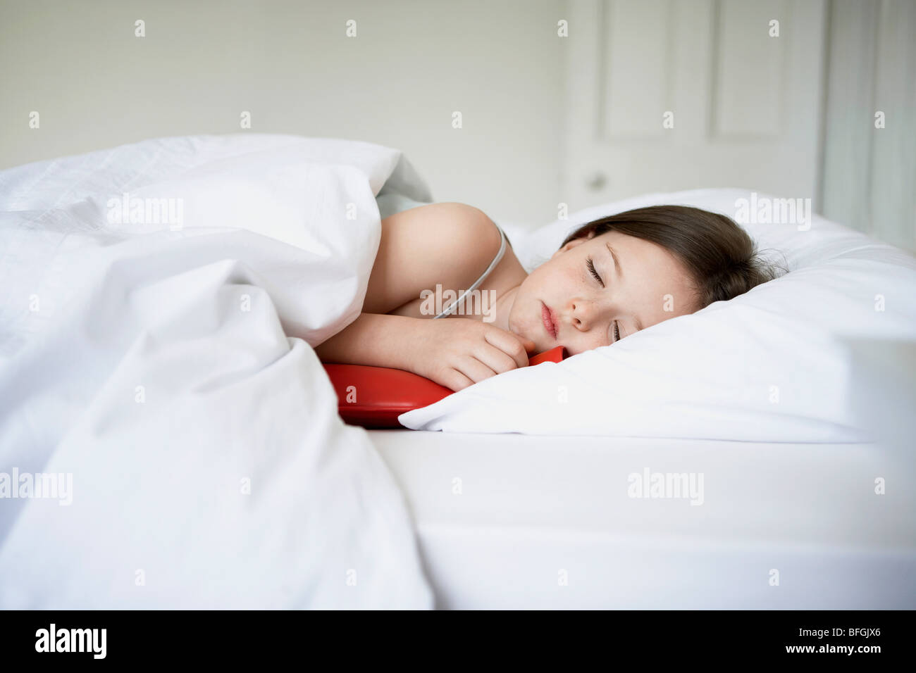 Niña con frío en la cama sosteniendo una botella de agua caliente  Fotografía de stock - Alamy