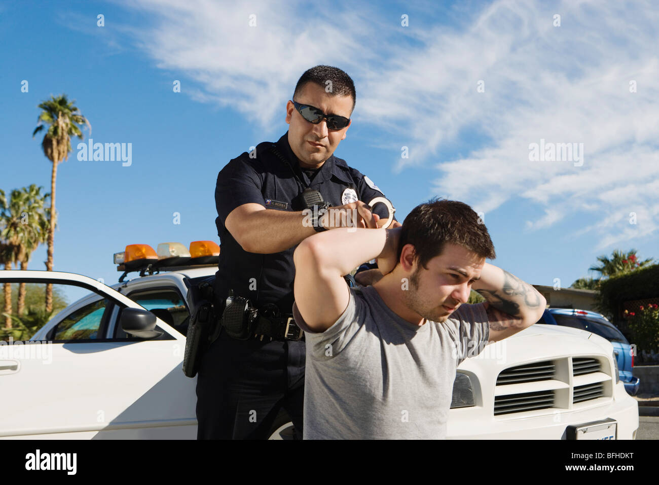 Oficial de Policía detener a hombre joven Foto de stock