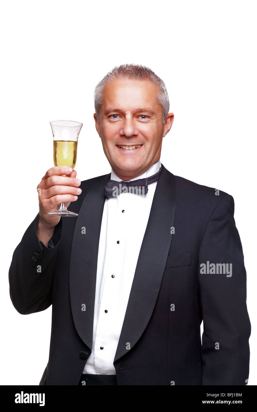 Un macho maduro vistiendo un esmoquin negro y pajarita, levantando una copa  de champagne, aislado en un fondo blanco Fotografía de stock - Alamy