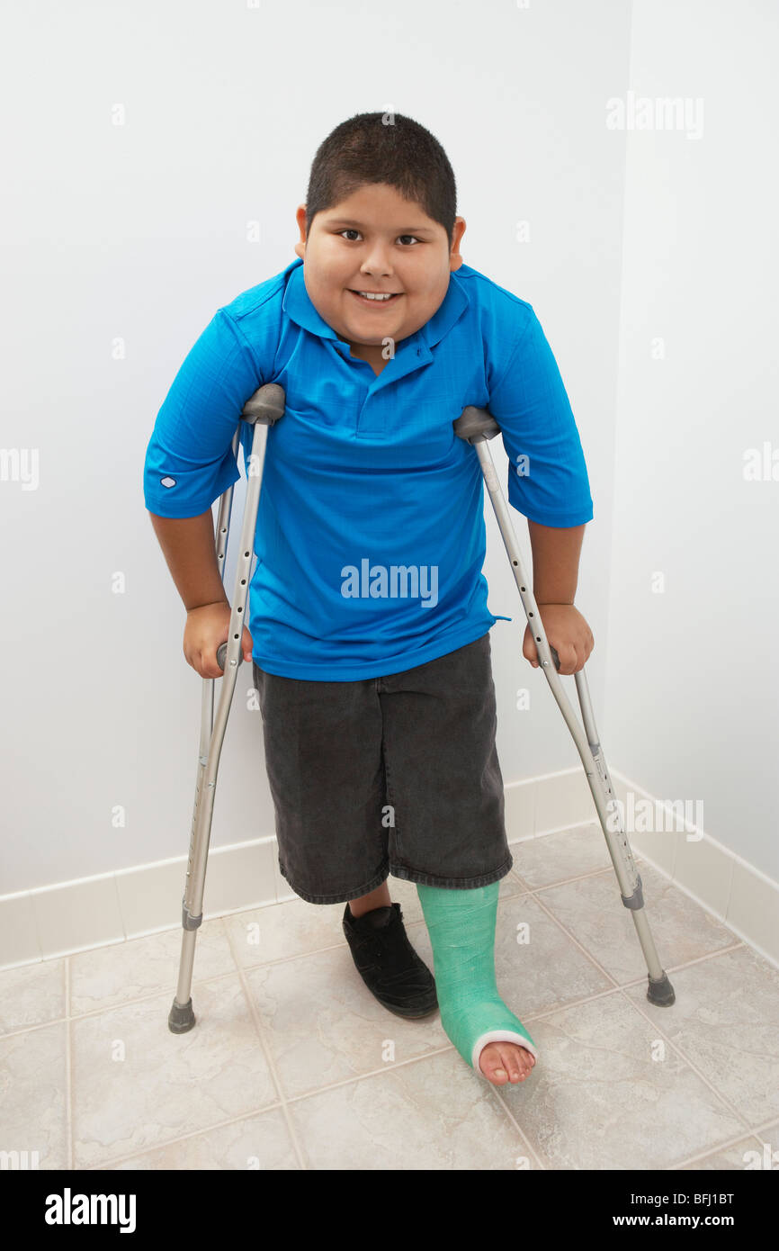 Niño de pie con muletas Fotografía de stock - Alamy
