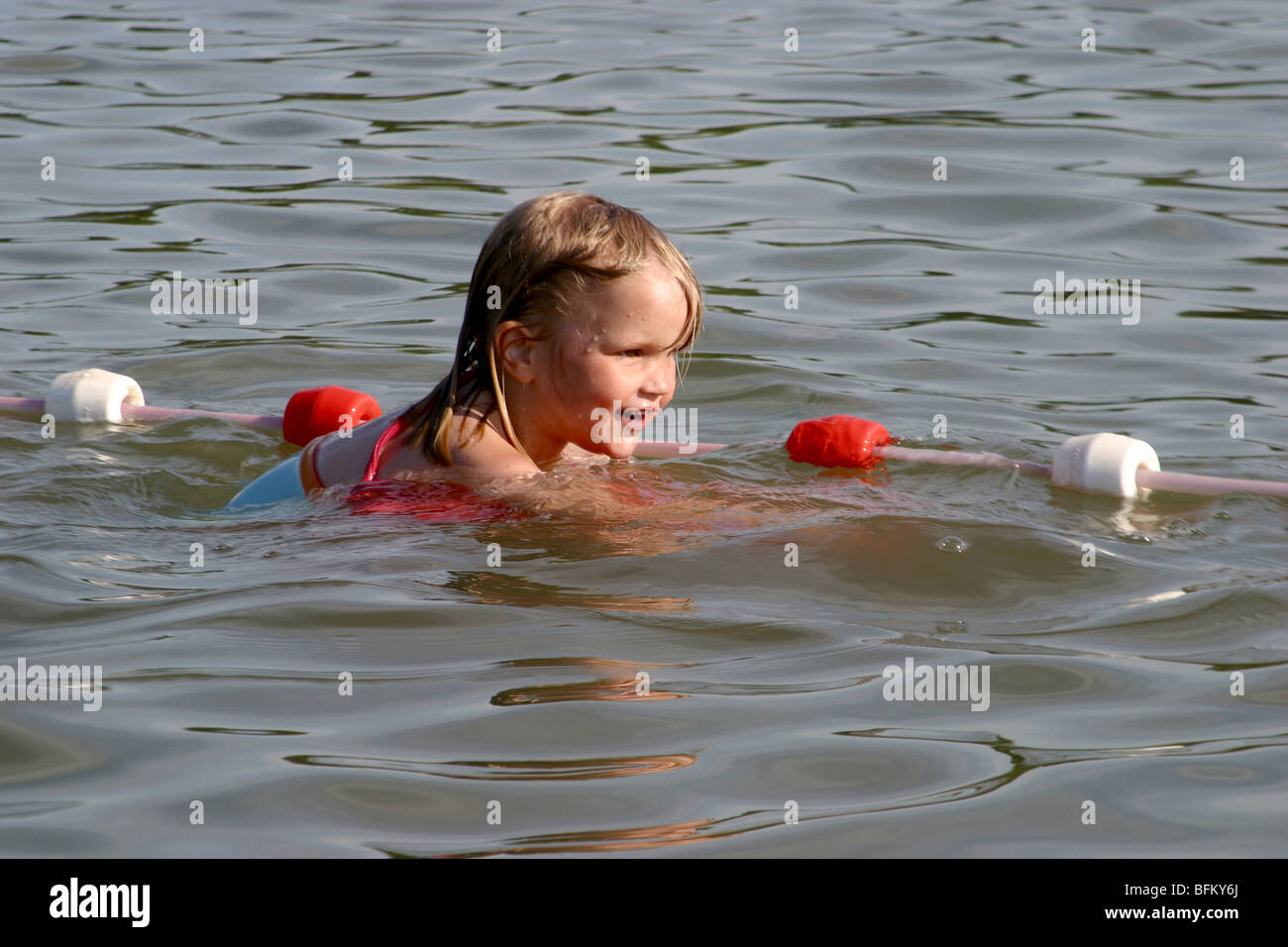 Chica con dispositivo floatable de natación en aguas abiertas. Foto de stock