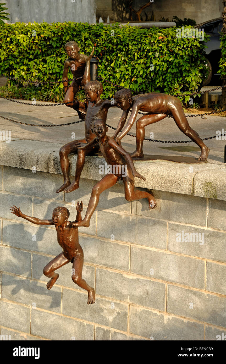 Esculturas de bronce, o el arte en la calle pública de chicos Juming en el río Singapur, Boat Quay, Singapur Foto de stock