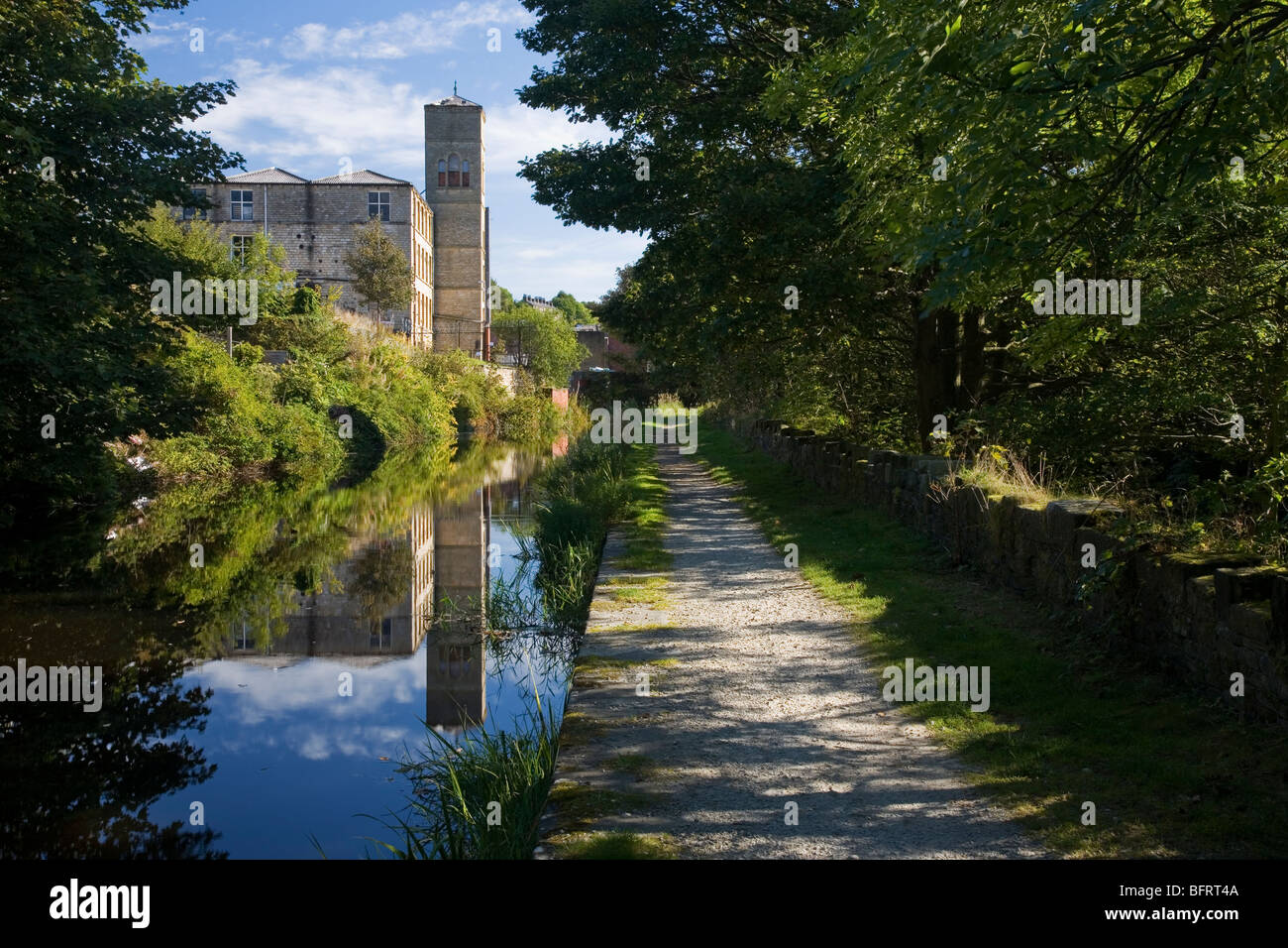 El Huddersfield Canal estrecho y antiguo edificio del molino en Slaithwaite en Colne Valley, Huddersfield, West Yorkshire, Reino Unido Foto de stock