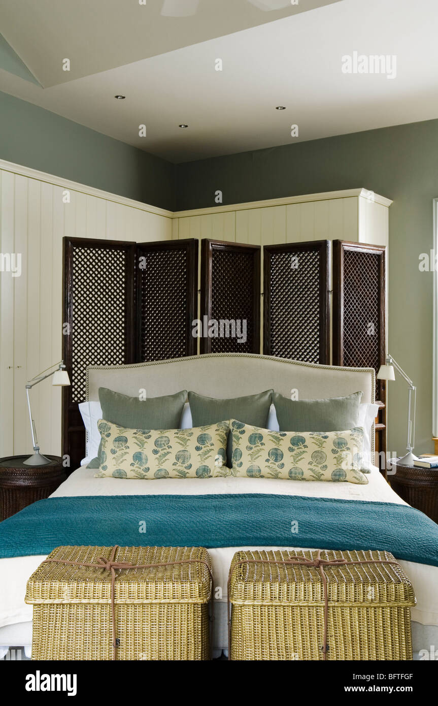 Dormitorio con cama de matrimonio contemporáneo, vestidores, pantalla y unidades de almacenamiento Foto de stock