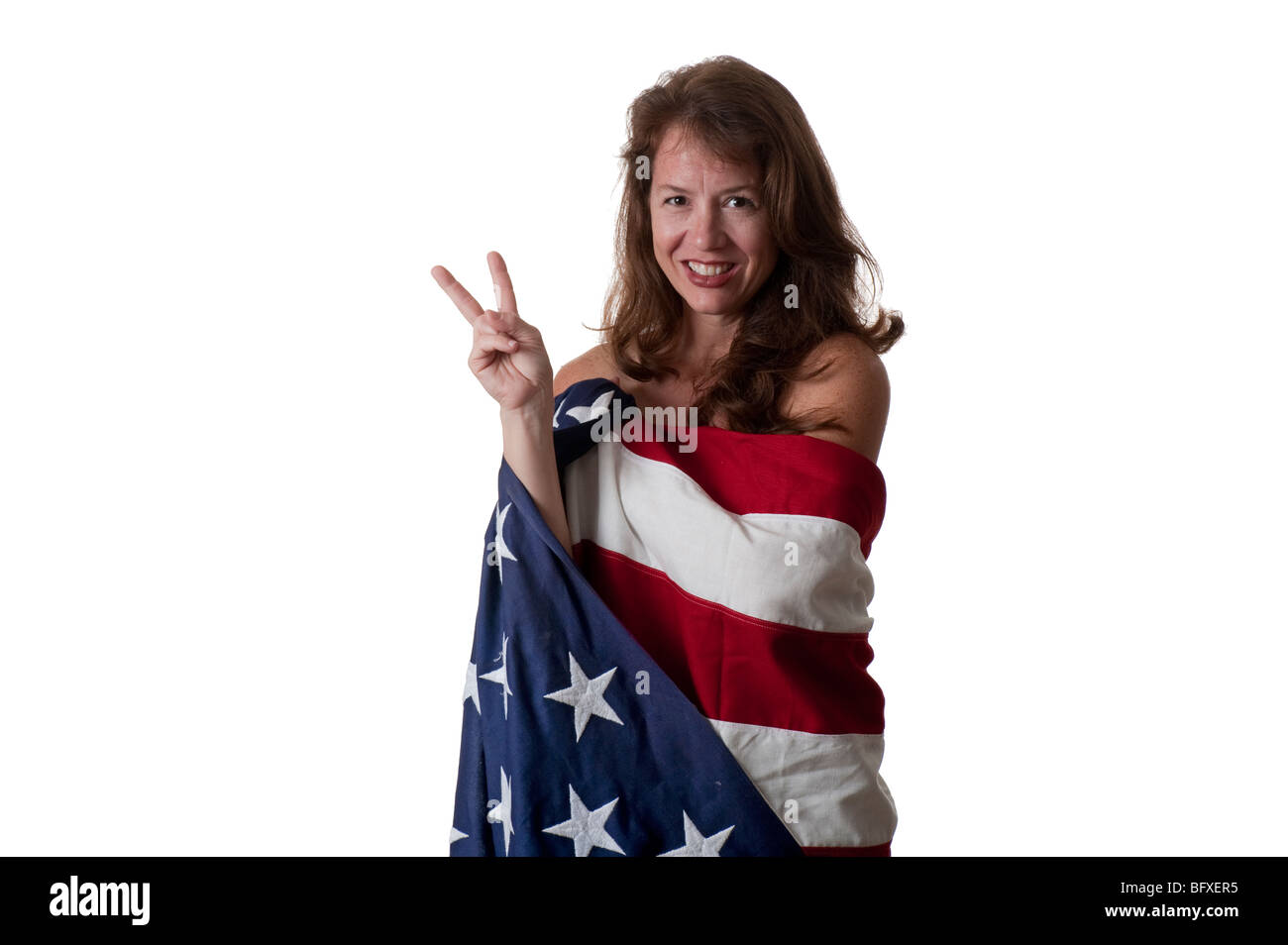Atractiva mujer joven envuelta en la bandera americana mostrando signos de paz Foto de stock