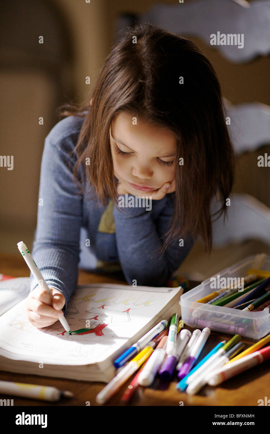 Cuatro años de edad, niña dibujo en libro para colorear. Foto de stock