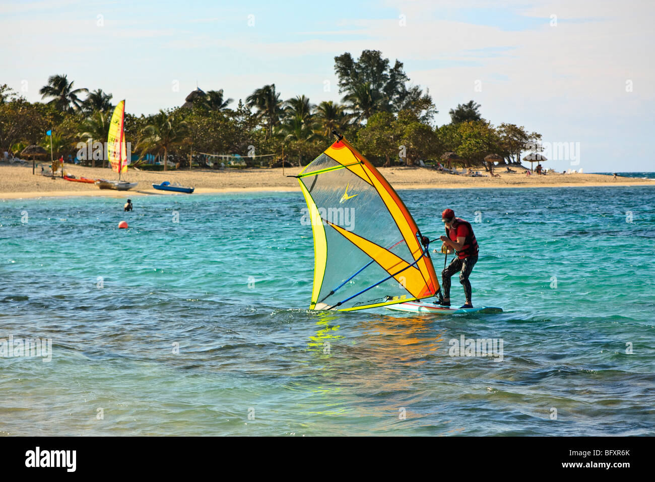 Altos funcionarios de windsurf en el Caribe entre arrecifes de coral Foto de stock