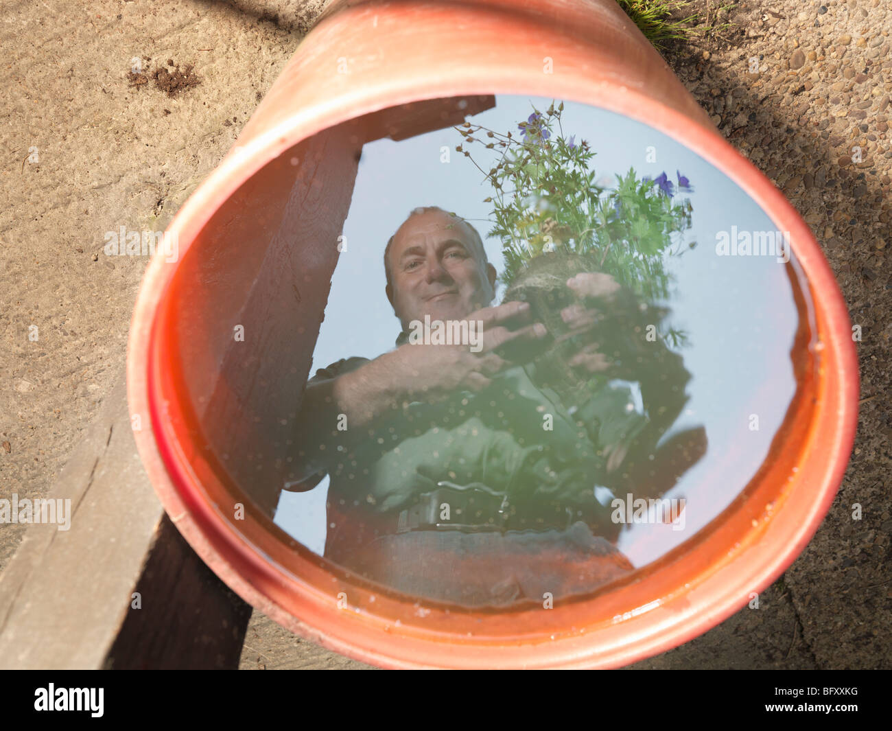 Reflejo de jardinero en el agua Foto de stock