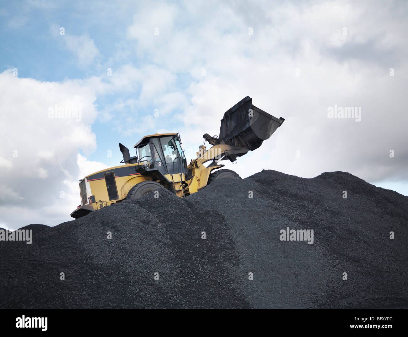 Excavadora sobre el montón de carbón en la mina Foto de stock