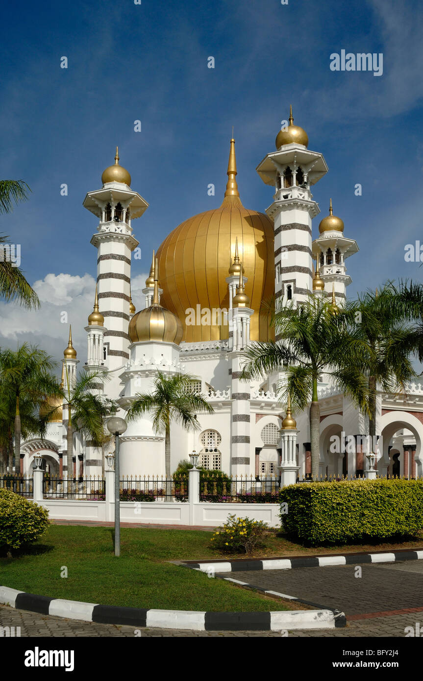 Cúpula dorada y minaretes de Masjid Ubudiah o Mezquita Real de Ubudiah (1917) por Arthur Benison Hubback enmarcado por palmeras Kuala Kangsar, Perak, Malasia Foto de stock