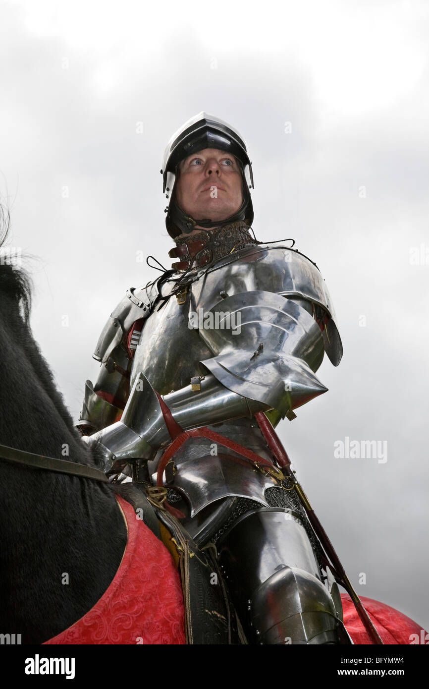 Caballero de brillante armadura medieval sobre el caballo negro Fotografía  de stock - Alamy