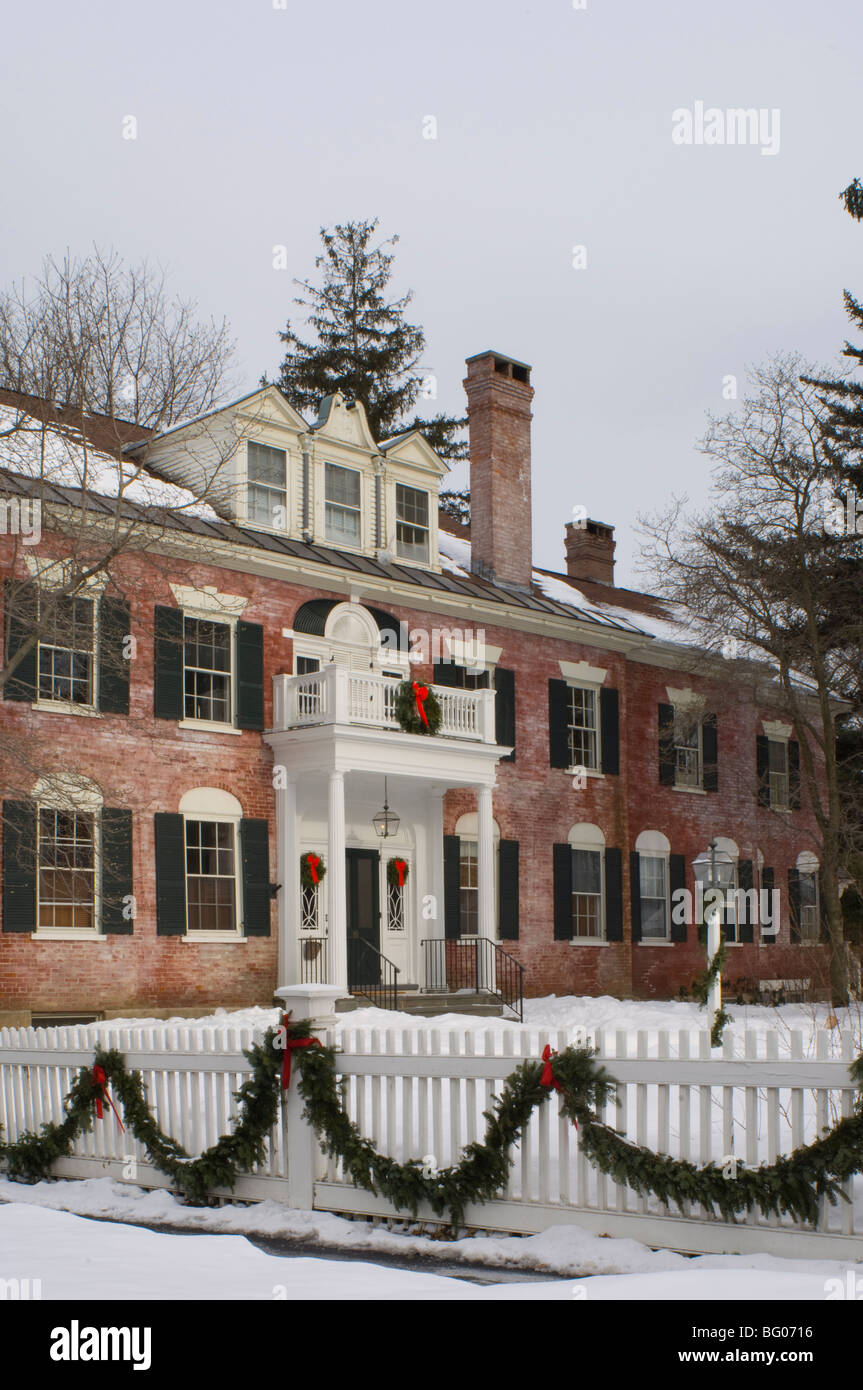 Una imponente casa de ladrillo rojo decorado para la Navidad con coronas y guirnaldas, Woodstock, Vermont, Nueva Inglaterra, EE.UU. Foto de stock