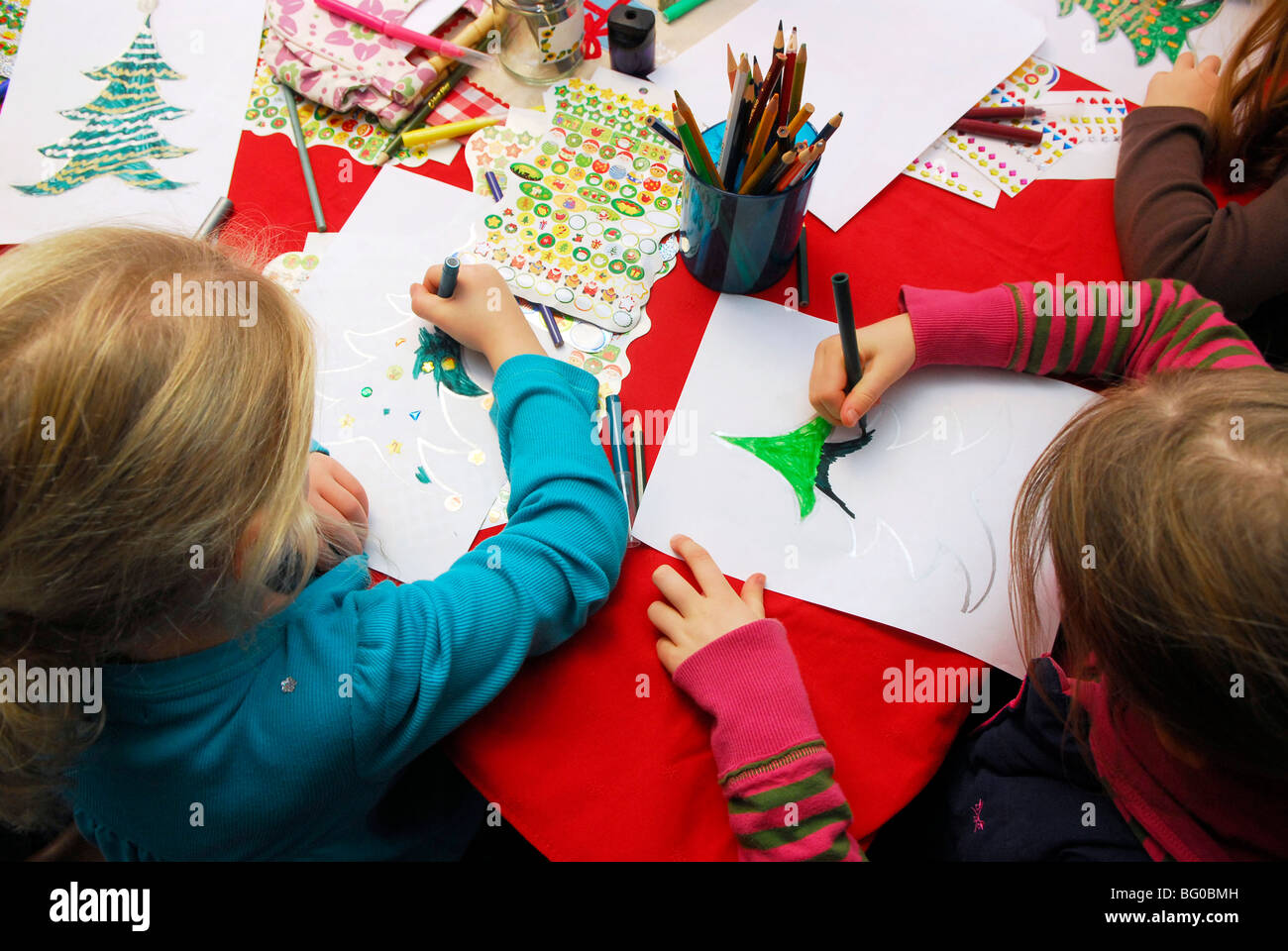 Los árboles de Navidad de dibujo para niños en una escuela Feria de Navidad, Haslemere, Surrey, Reino Unido. Foto de stock