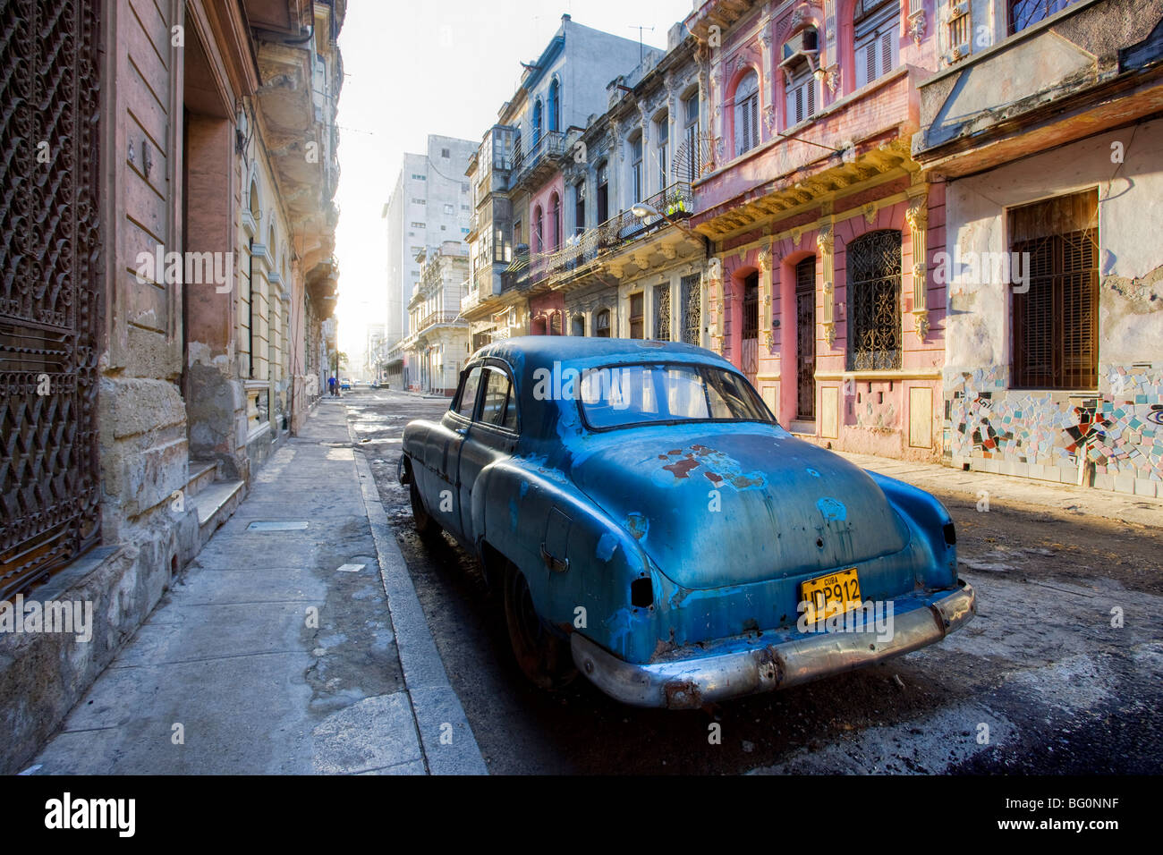 Destartalado coche americano estacionado en una calle de ornamentados edificios coloniales, Centro Habana, Ciudad de La Habana, Cuba, Las Antillas Foto de stock