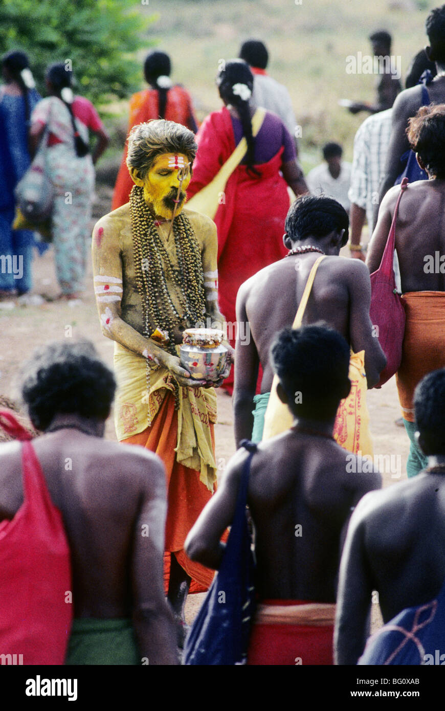 Un mendigo en el anual festival Thaipusam hindú en el sur de la ciudad india de Palani, en el estado de Tamil Nadu, pinta su rostro amarillo para atraer la atención y penetra su lengua con un tridente, el Hindú arma con la cual el dios Hindú Shiva destruye males y restablece el orden. Foto de stock