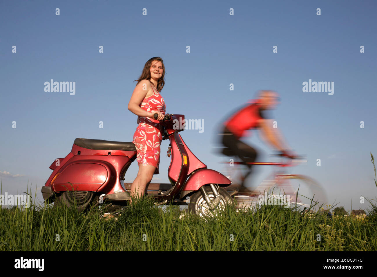 Mujer con una vespa , hombre con una bicicleta de carreras Foto de stock