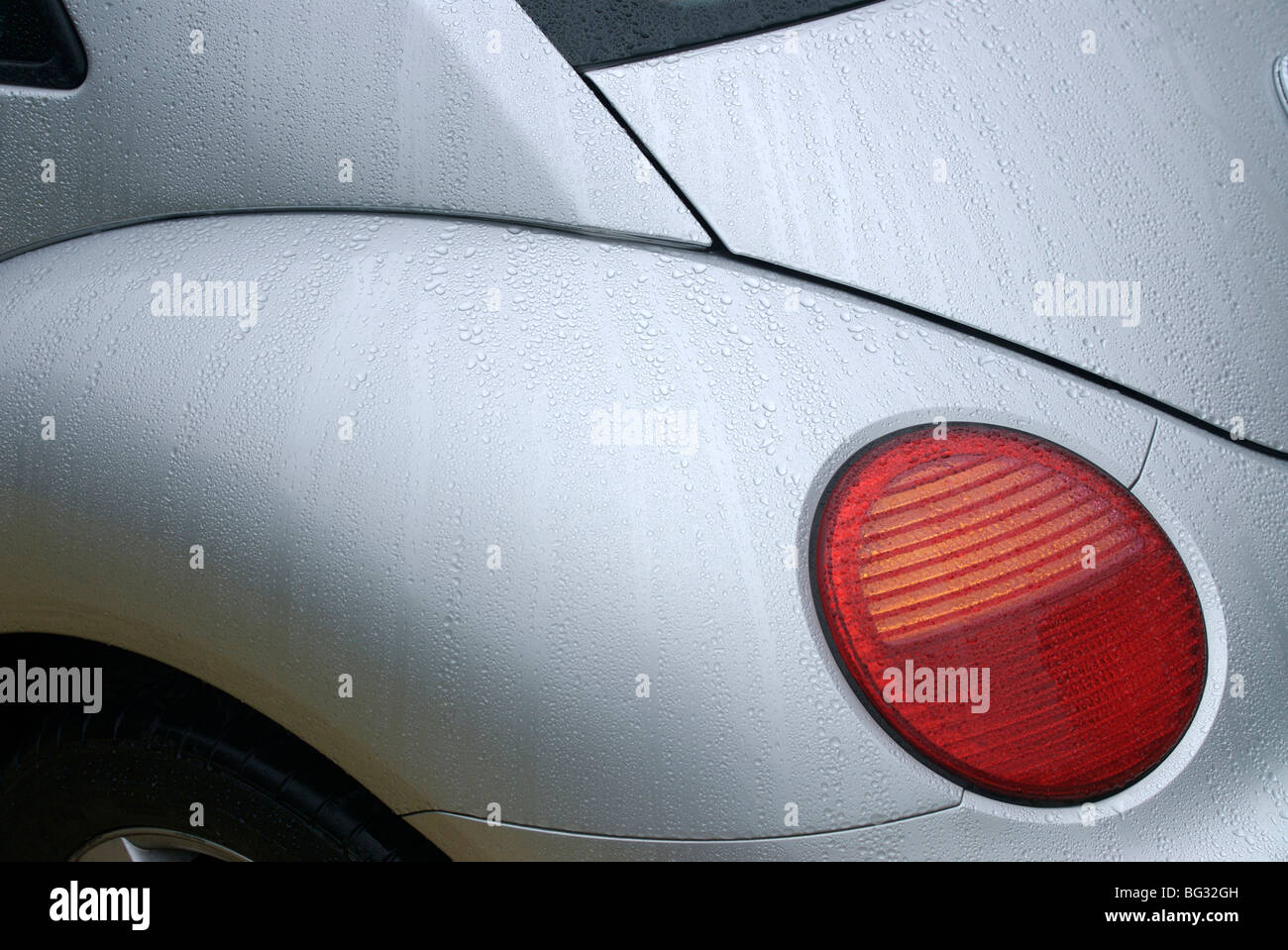 La luz de la mañana y la lluvia de gotas añadidas a la composición abstracta de la ' coche 's luz y guardabarros de plata Foto de stock