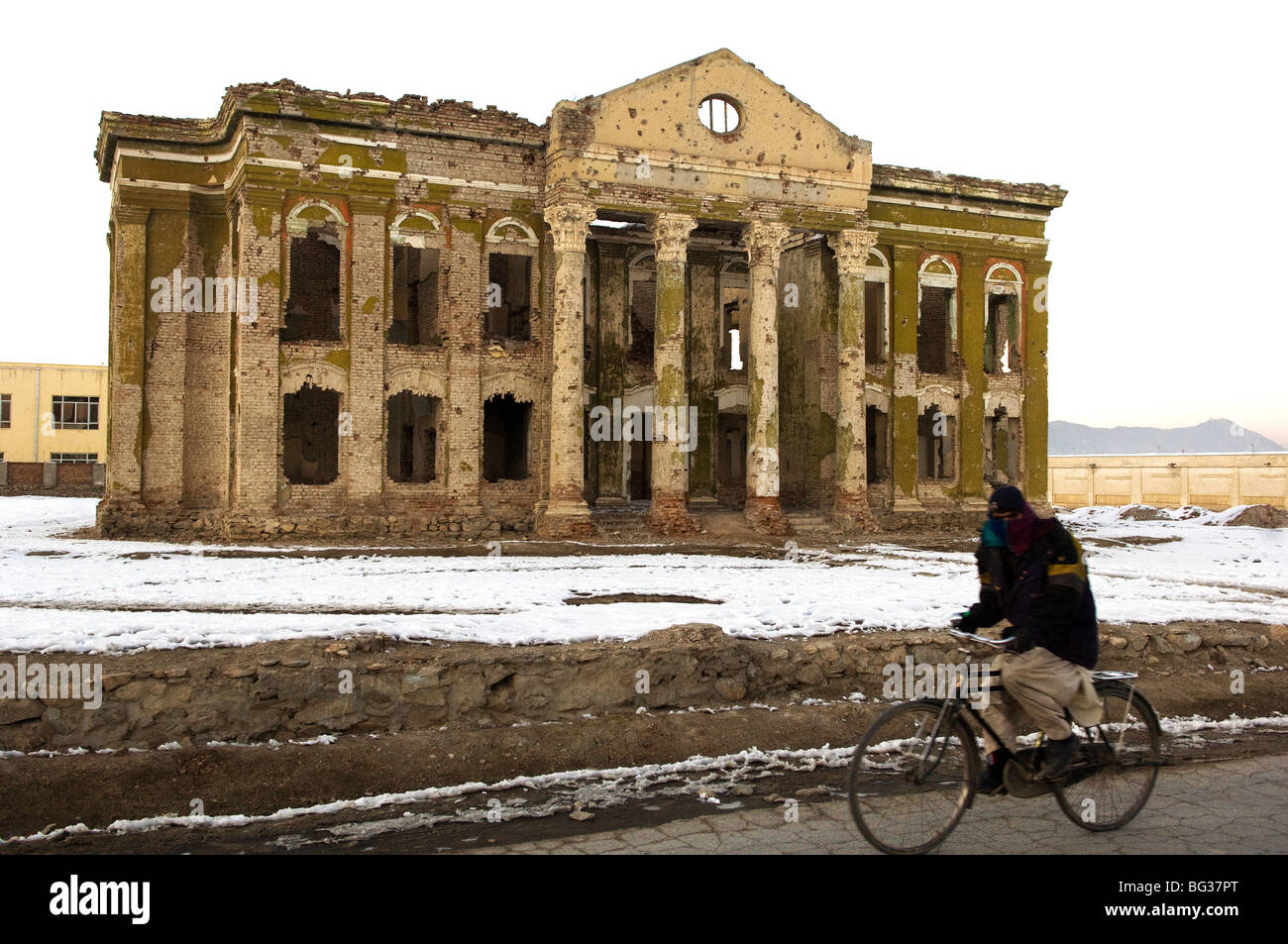 Hombre afgano el ciclismo sobre la nieve cerca del Palacio Darul Aman Kabul, Afghanisan. Foto de stock