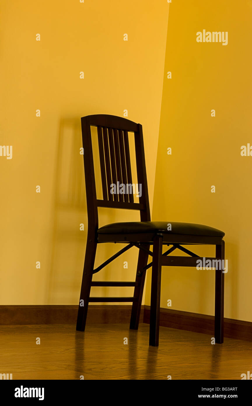 Simplemente una imagen de una silla en una esquina. Foto de stock