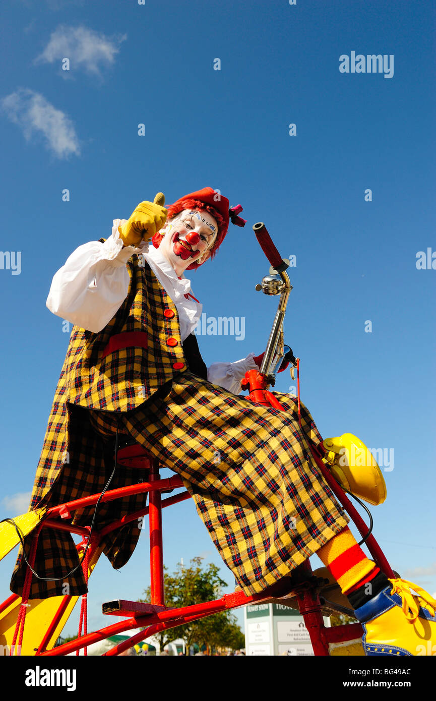 Payaso en triciclo contra el cielo azul Fotografía de stock - Alamy