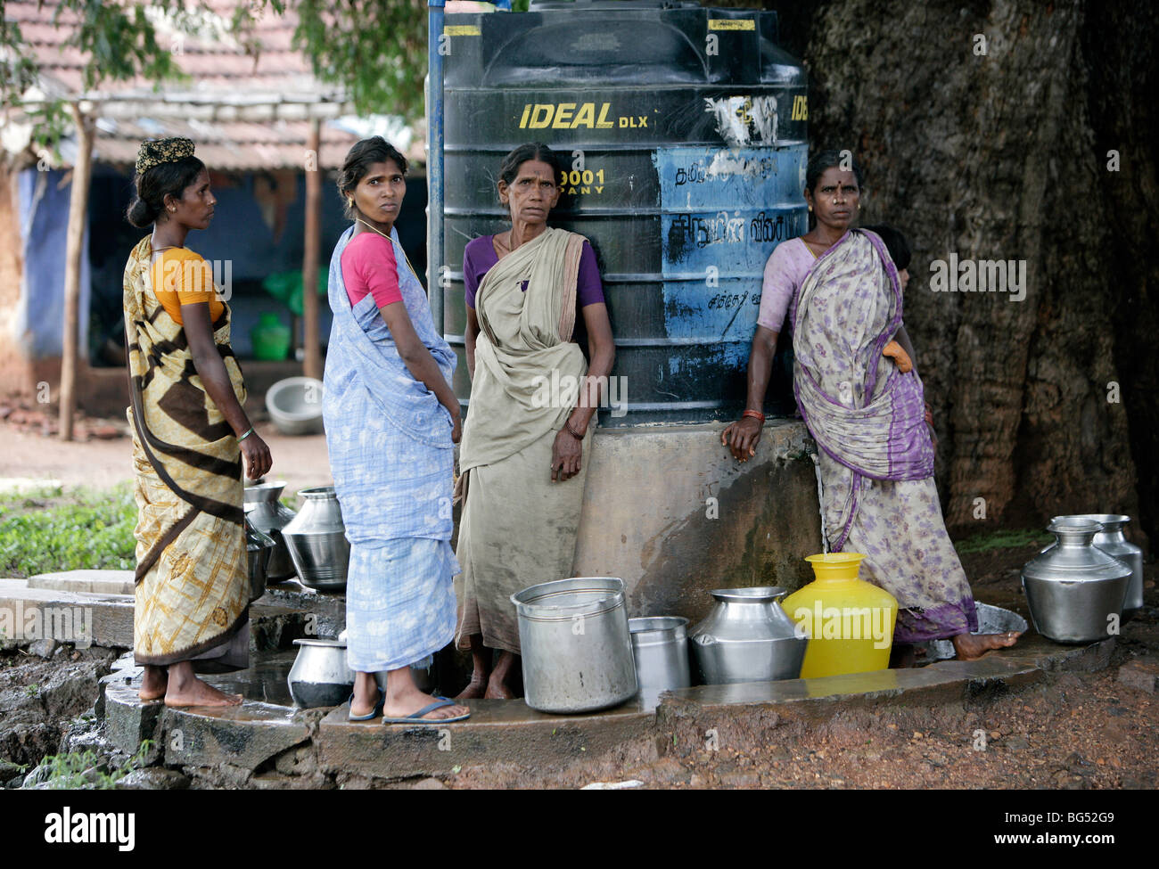 Las mujeres recoger agua de un tanque de agua dulce en una aldea en Tamil Nadu, India Foto de stock