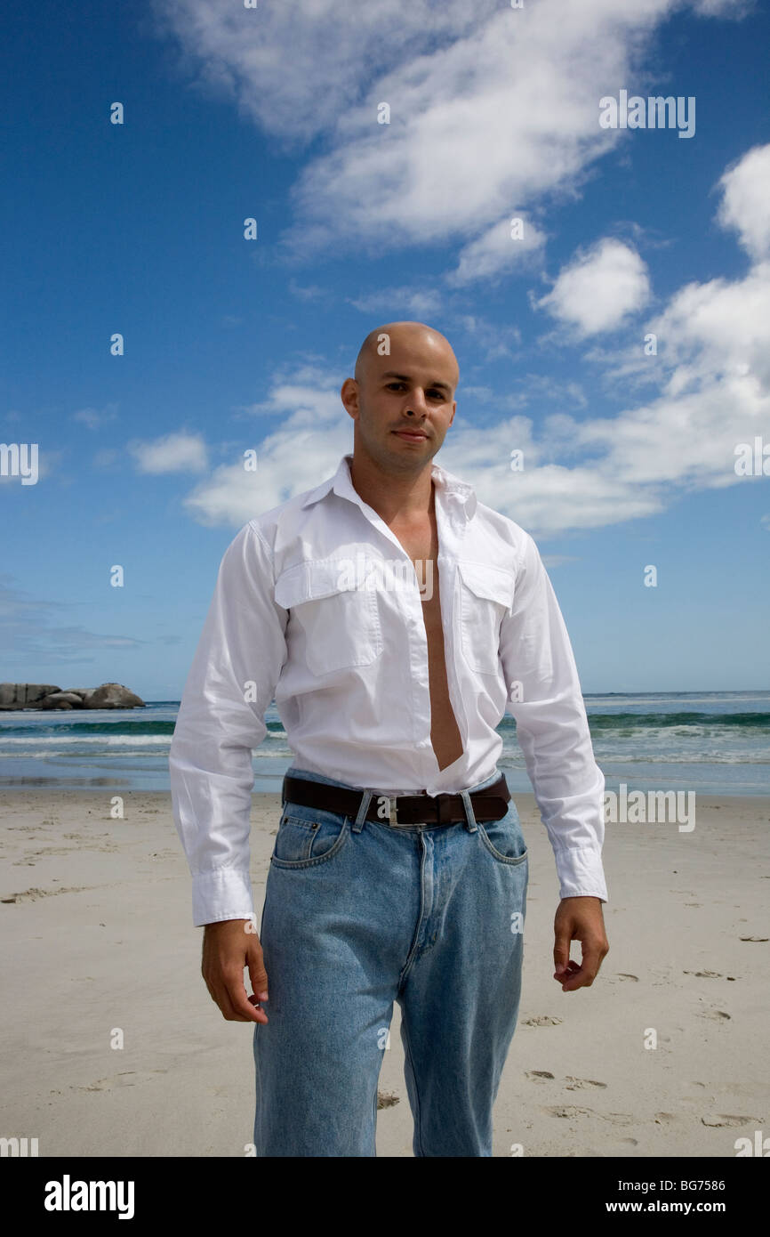 Hombre con camisa blanca y jeans en la playa Fotografía de stock - Alamy