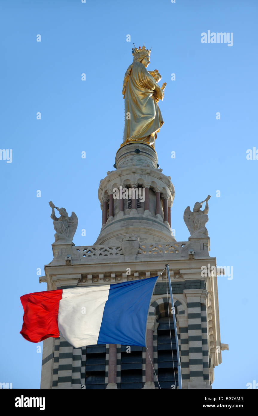La torre de la iglesia o campanario de la catedral de Notre Dame de la Garde, la iglesia Madonna & Child & bandera francesa, Marsella, Provenza, Francia Foto de stock