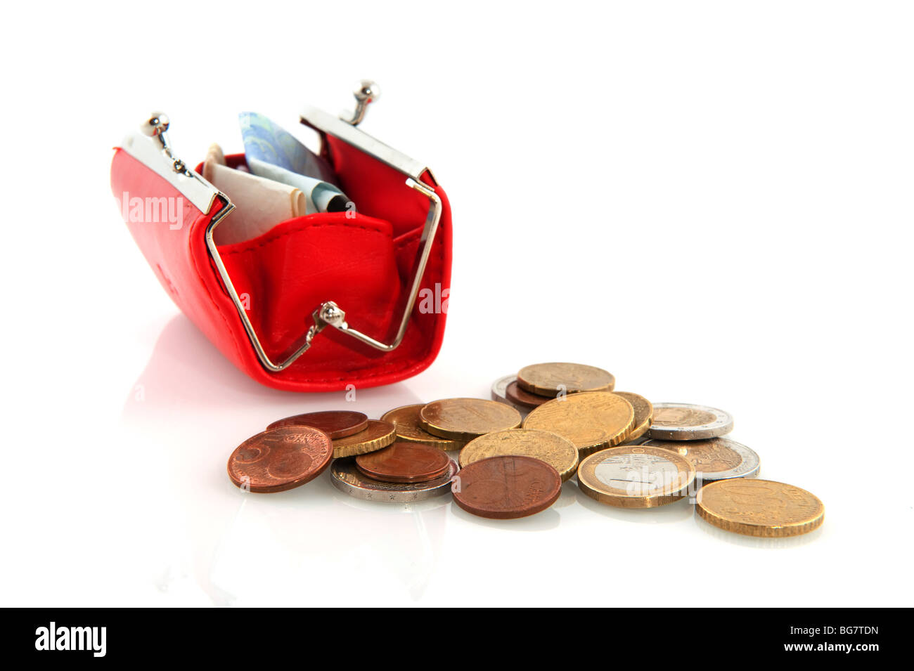 Las monedas y billetes en un monedero rojo Foto de stock