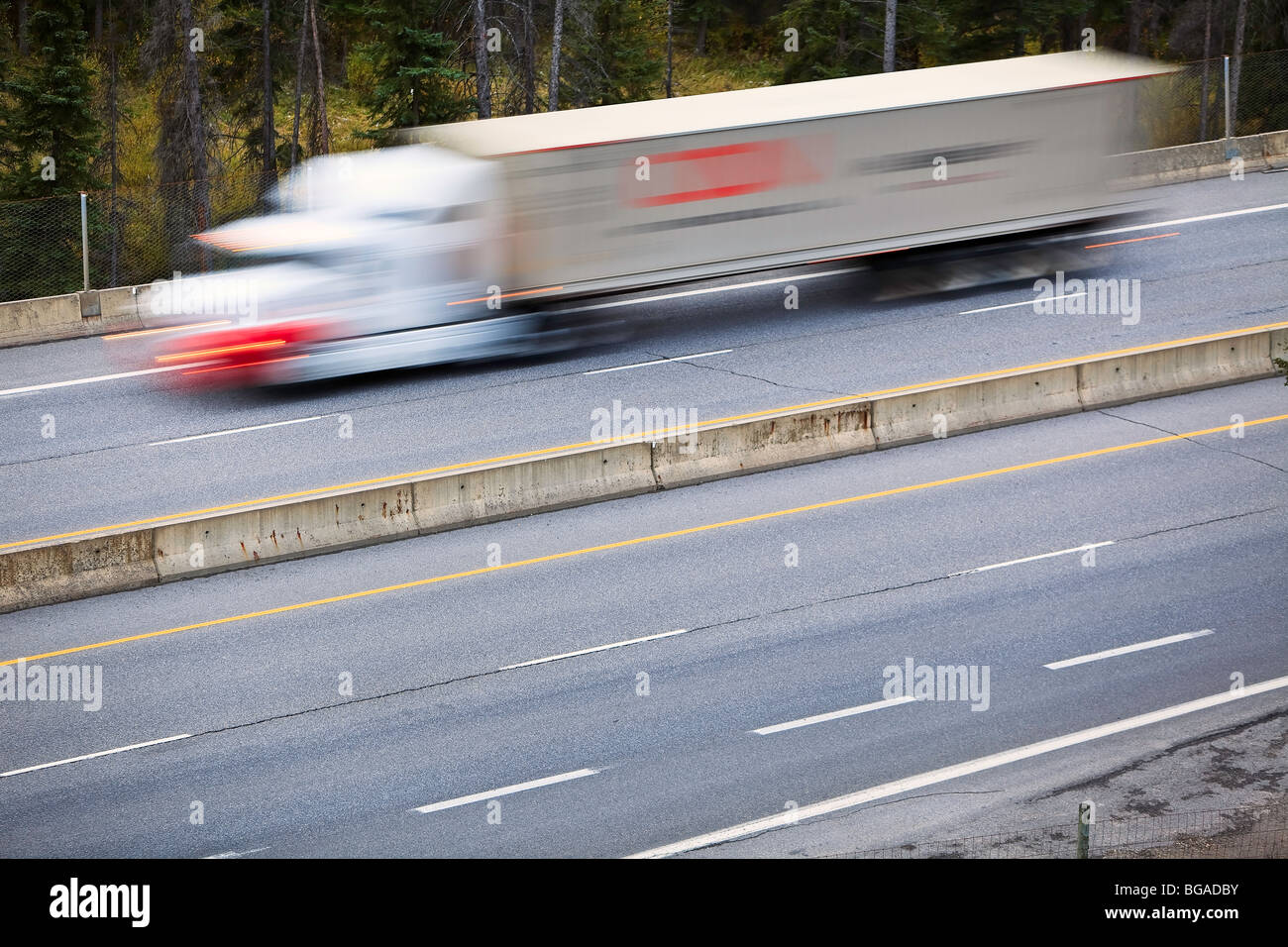 Imagen borrosa de movimiento de un camión de transporte de la autopista Trans-Canada, Parque Nacional de Banff, Alberta, Canadá. Foto de stock
