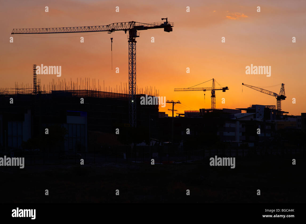 Grúas torre silueteado en un sitio de construcción Foto de stock