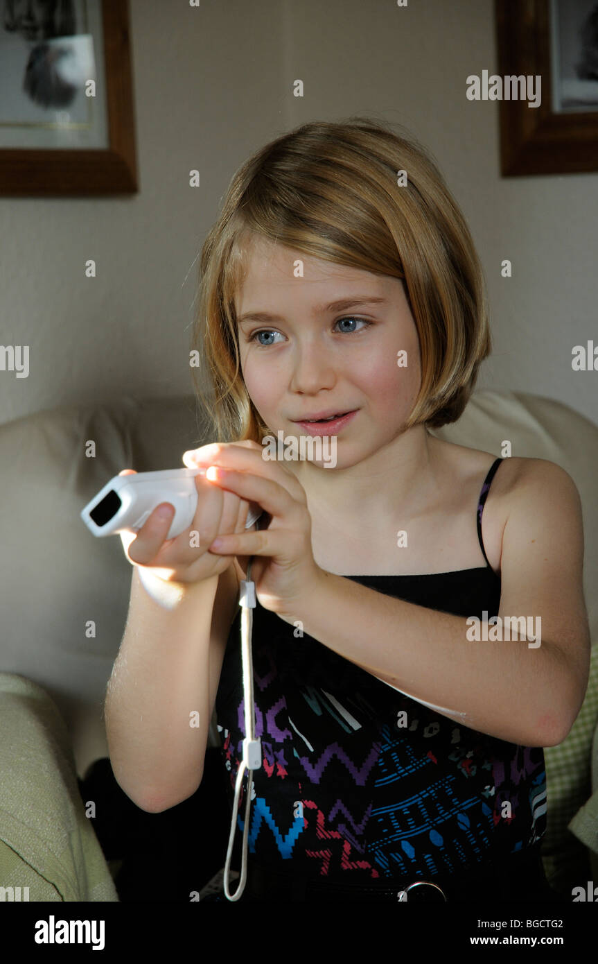 Retrato de una joven con un controlador de juego de Wii Foto de stock