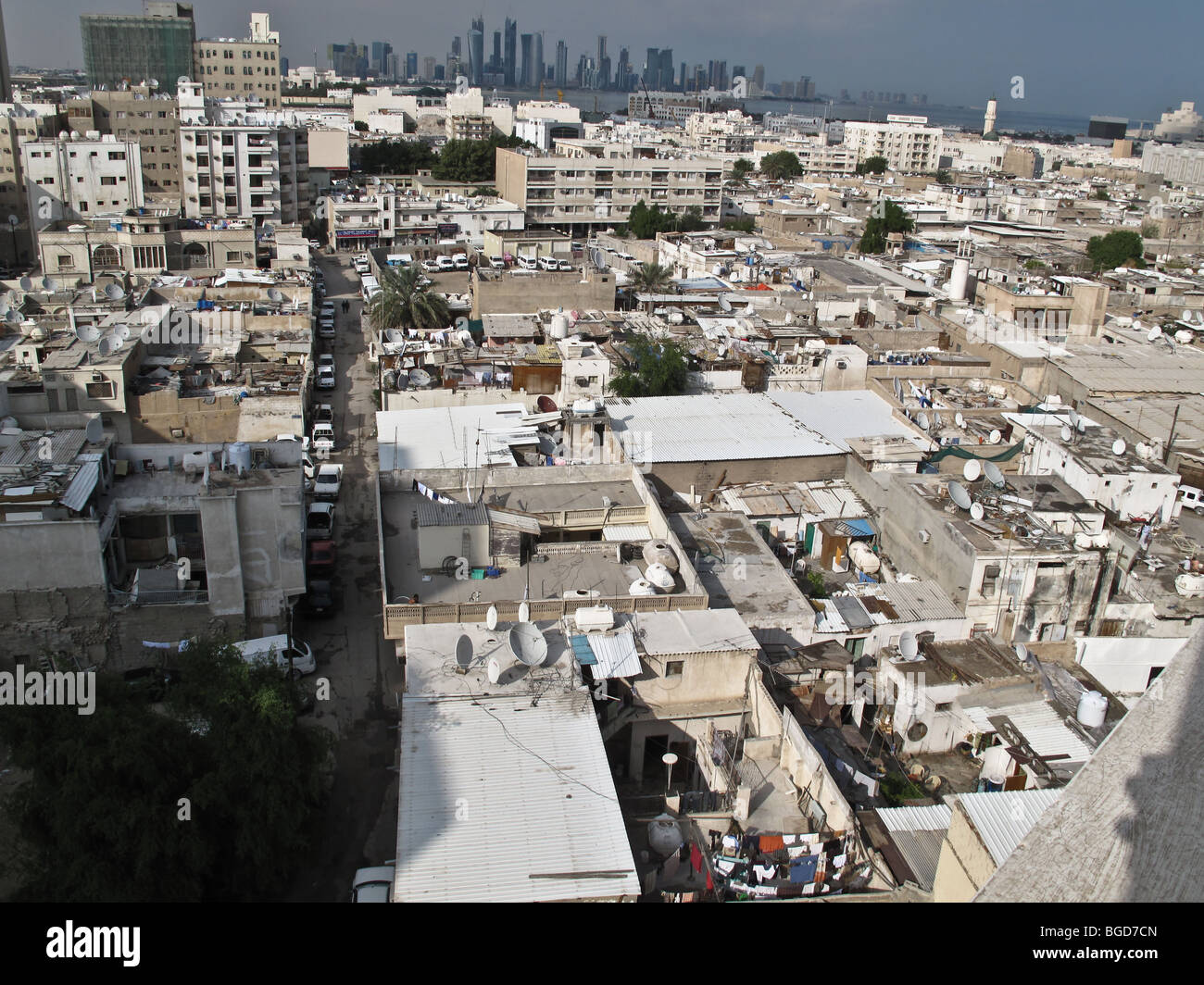 Los tugurios de Doha, Qatar, medio oriente GCC golfo pérsico la pobreza laboral de trabajadores hogar residencia miseria con skyline en segundo plano. Foto de stock