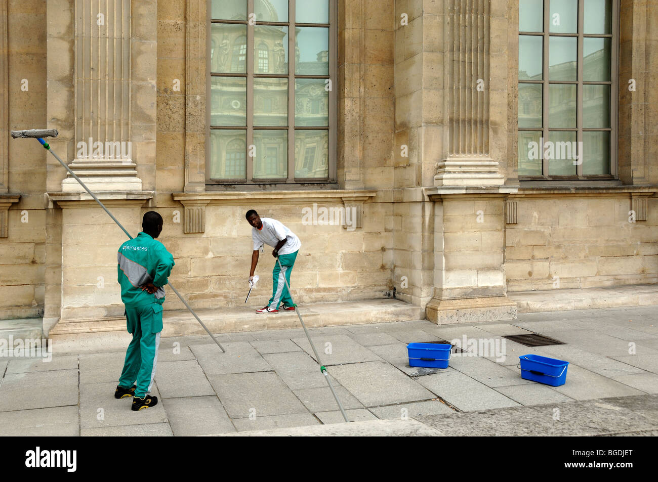 Trabajadores inmigrantes africanos, trabajadores extranjeros o extranjeros limpiando ventanas del Museo del Louvre, París, Francia Foto de stock