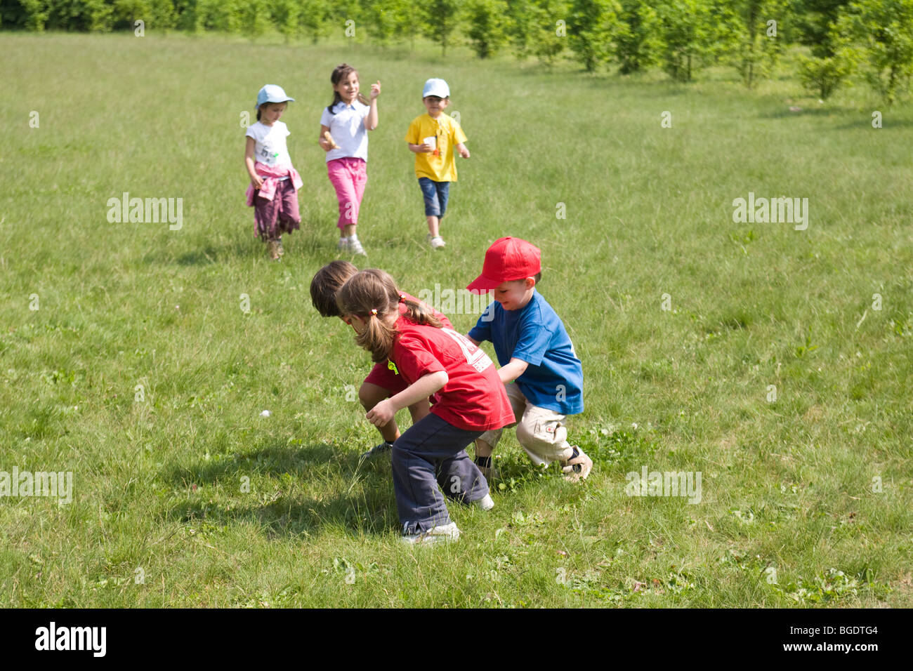 Niños jugando alegremente en un campo juntos Foto de stock